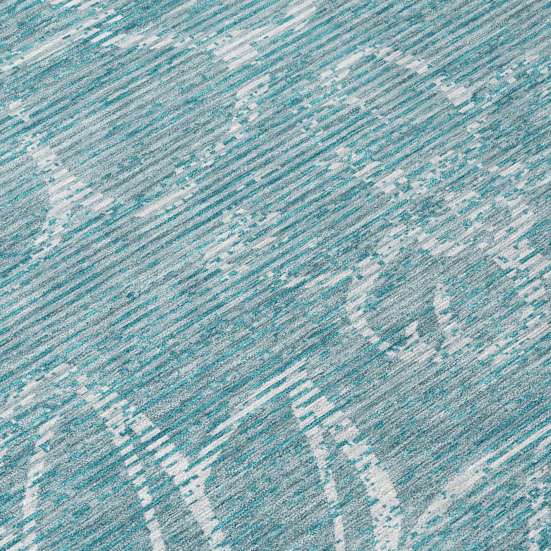 Teal blue rug close-up with distressed speckled stripes and white pattern accents