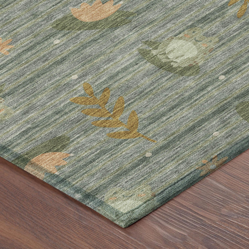 Green area rug with faded botanical leaves, tan and orange accents, corner view