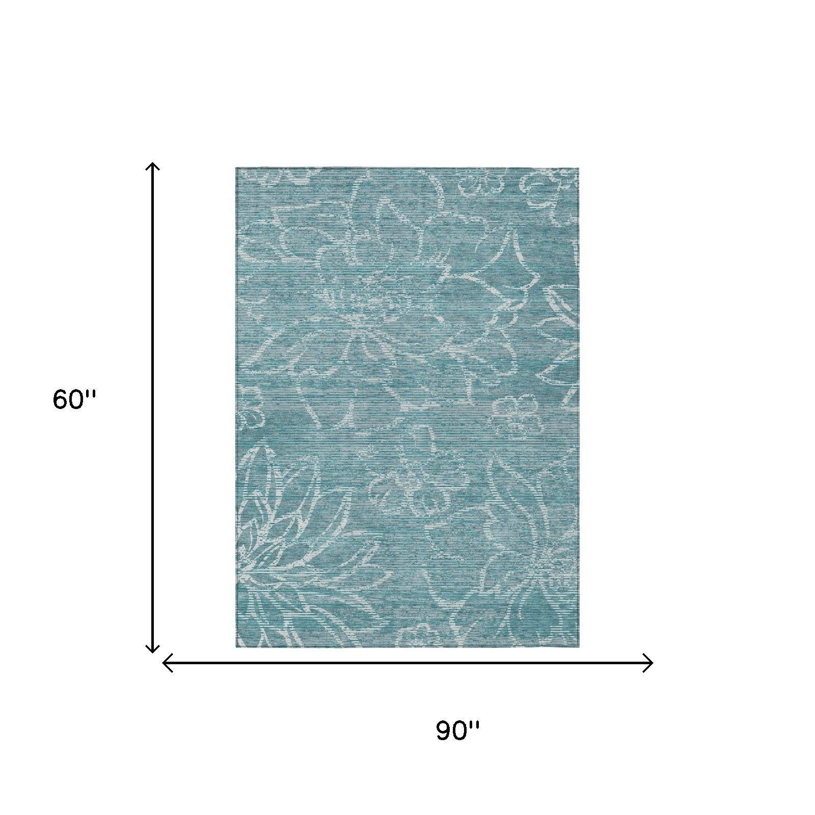 Teal-blue rectangular area rug with white distressed floral motifs