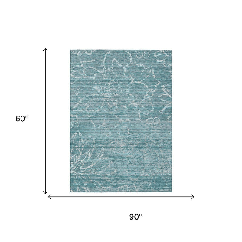 Teal-blue rectangular area rug with white distressed floral motifs