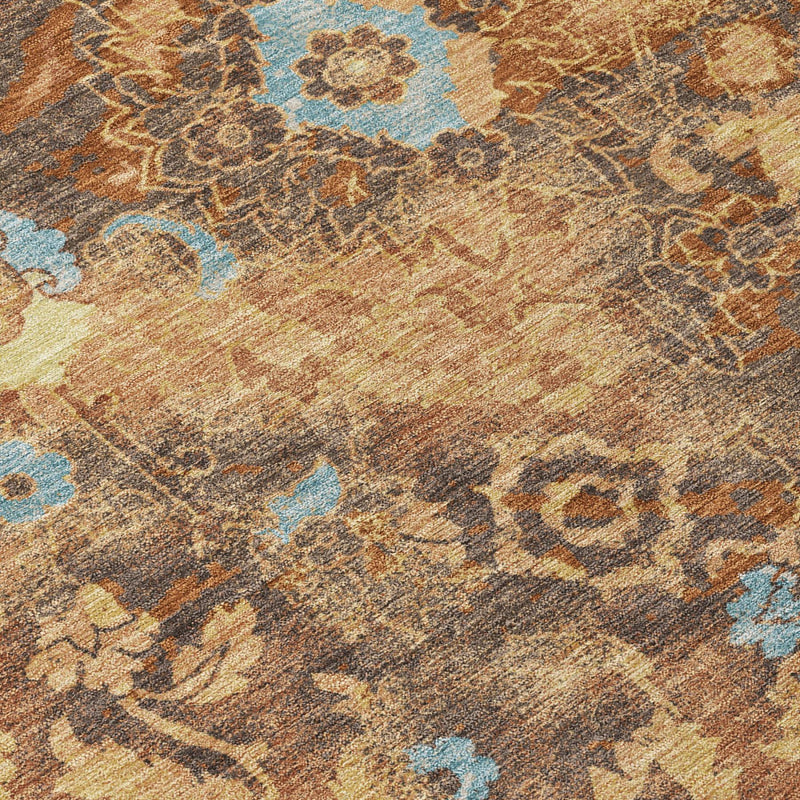 Textured floral area rug close-up in warm orange and rust with teal-blue accents
