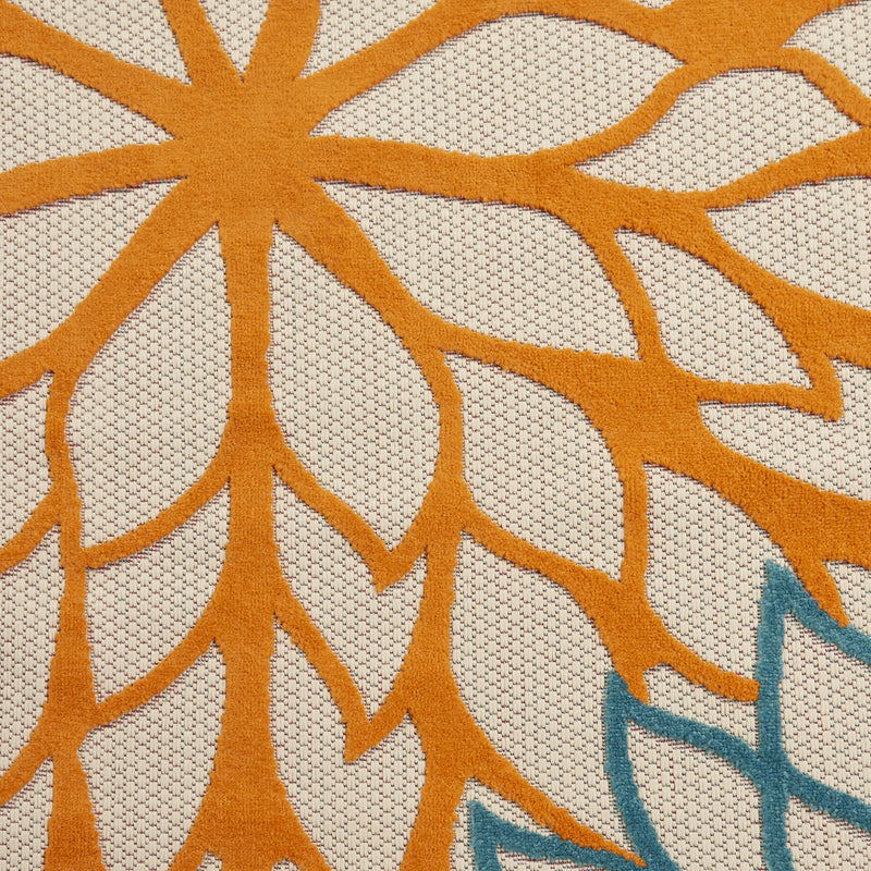 Ivory floral area rug close-up with orange sunburst petals and small blue accents