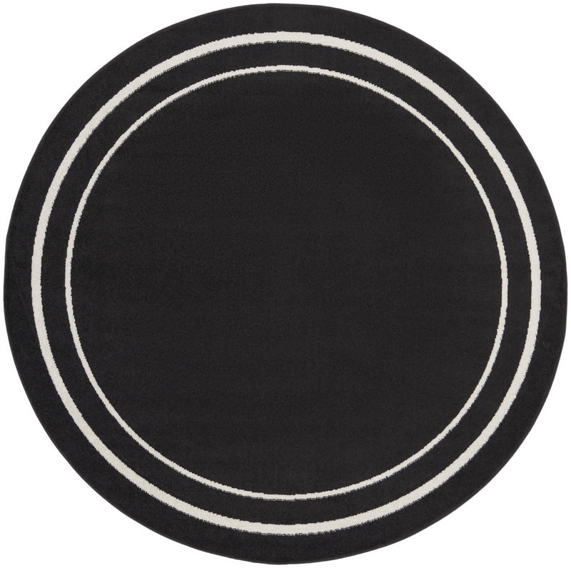 Round black area rug with ivory concentric circles and triple ring border, flat lay