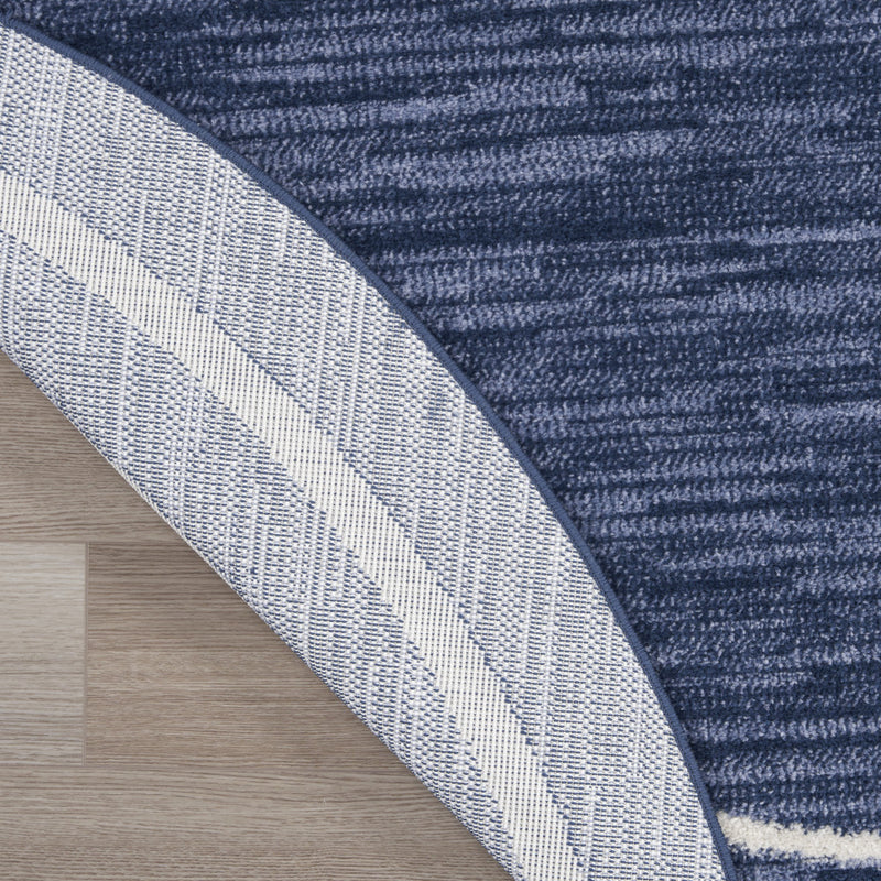 Navy and ivory round rug corner view showing striped border and woven texture.