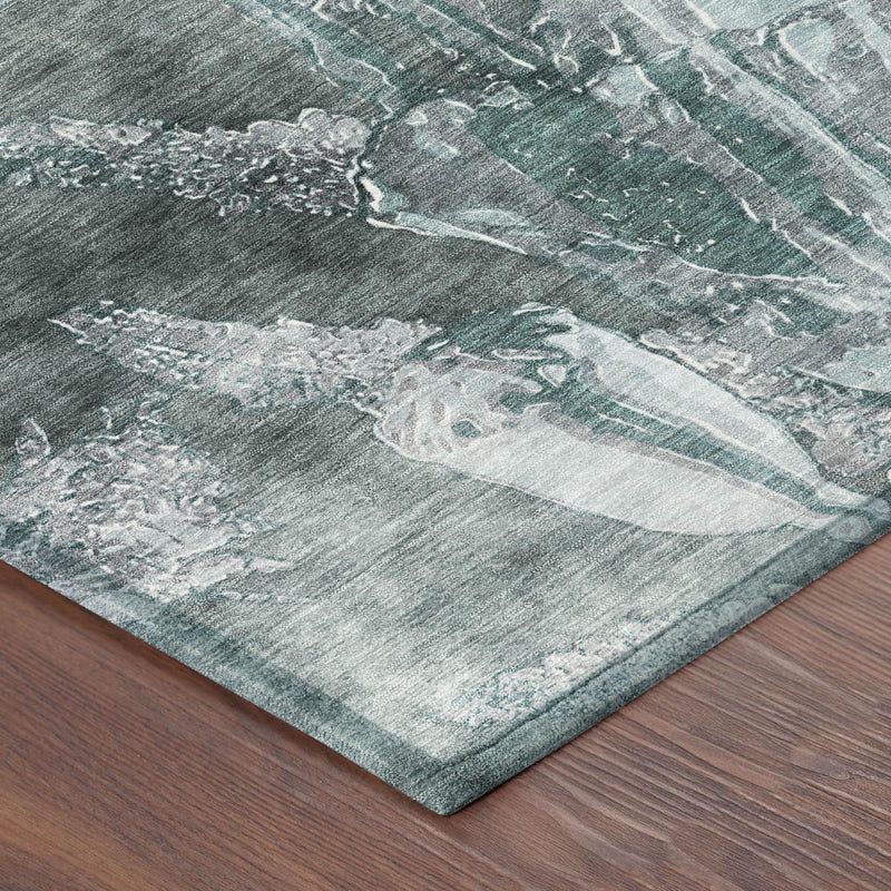 Rug corner with teal blue, graphite, and distressed white floral abstract pattern