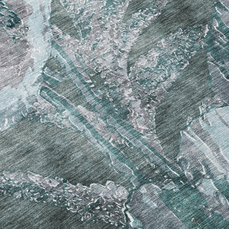 Close-up of teal and graphite floral rug, distressed weave and faded pattern