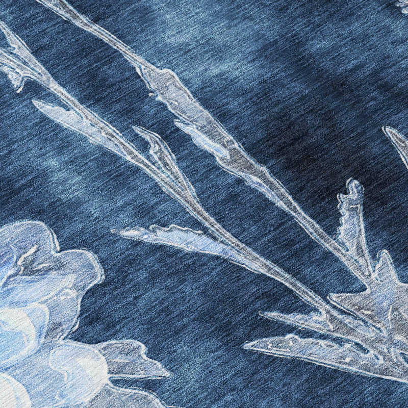 Close-up of round area rug: dark navy background with light-blue botanical linework