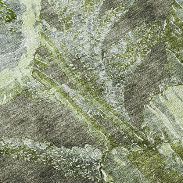 Green and silver floral patterned area rug, distressed texture close-up.