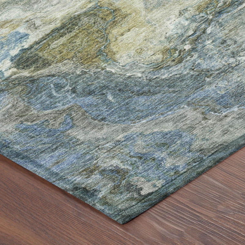 Corner view of round area rug with blue-gray abstract texture and binding edge