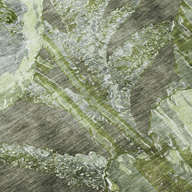 Close-up of green and silver abstract floral pattern on textured area rug.