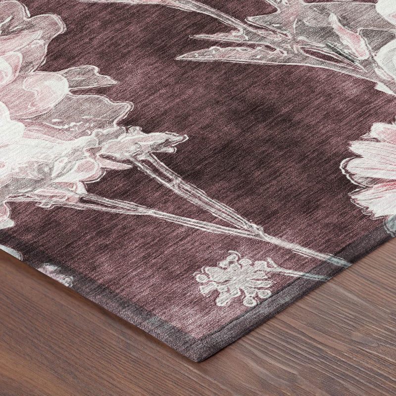 Corner view of round burgundy rug with white floral print on flat weave