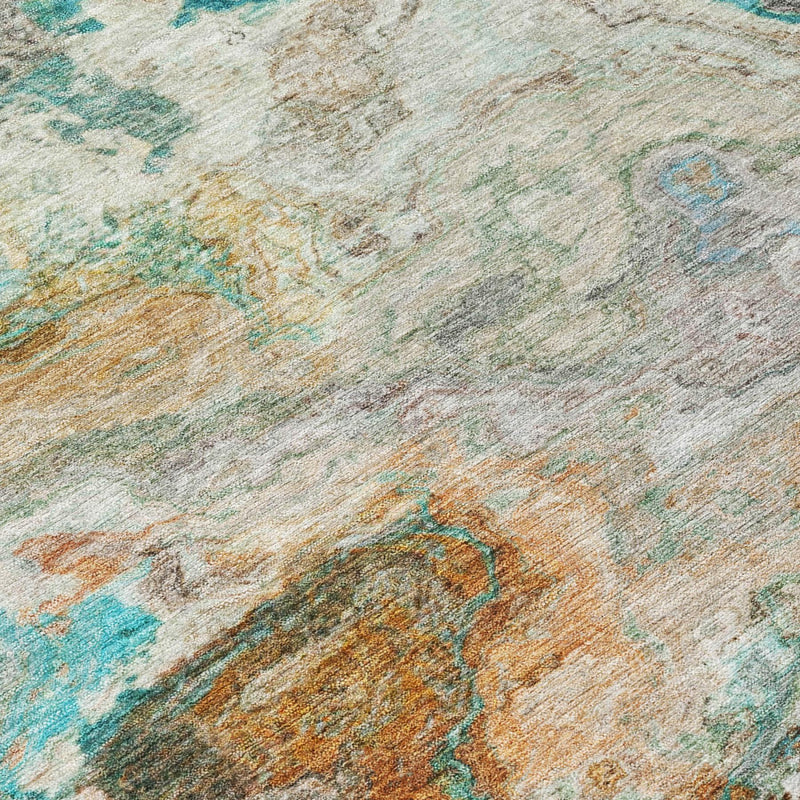 Close-up of round area rug texture with aqua, teal, tan, and gray abstract swirls