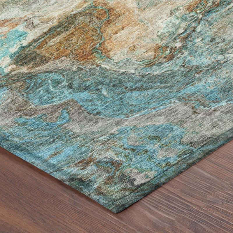 Corner view of round abstract area rug with teal and tan tones on wood flooring