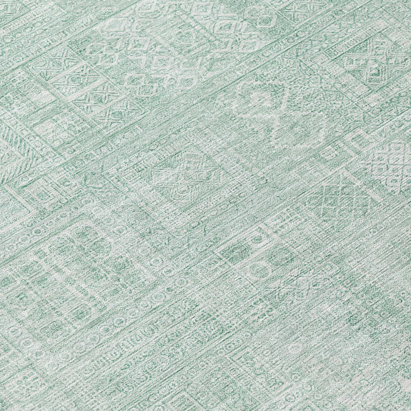 Close-up of mint-aqua rug with intricate oriental geometric motifs in a distressed finish.