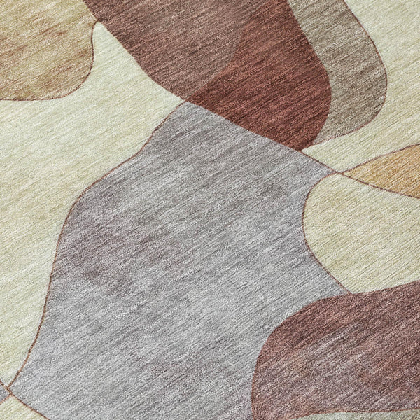 Round abstract area rug with patchwork shapes in gray, beige, and rust brown