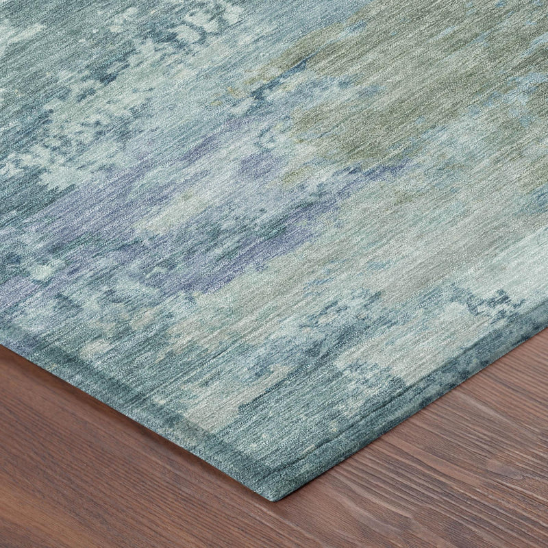 Corner view of teal blue and silver abstract area rug with distressed pile texture