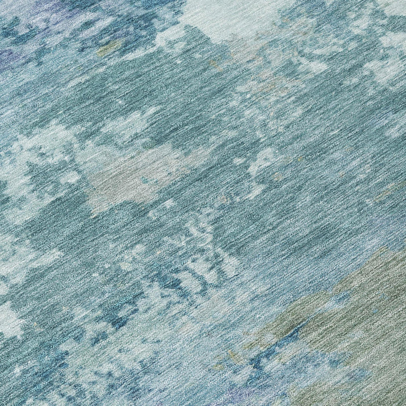Close-up of teal blue and silver abstract area rug with textured mottled pattern