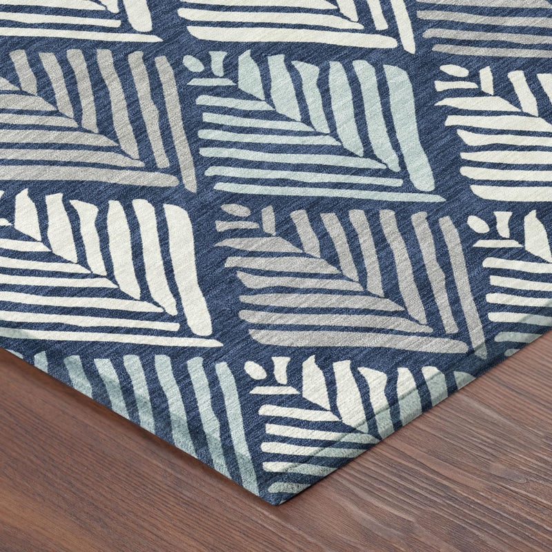 Navy and light blue geometric area rug corner with stitched border, indoor-outdoor