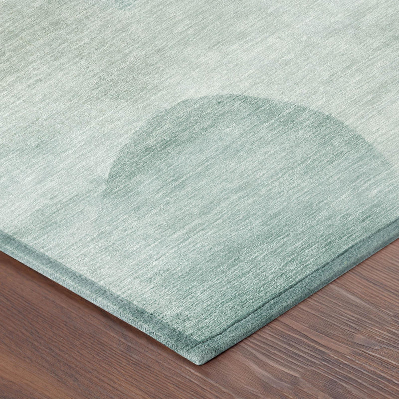 Round teal and off-white abstract geometric area rug corner view with flat weave edge.