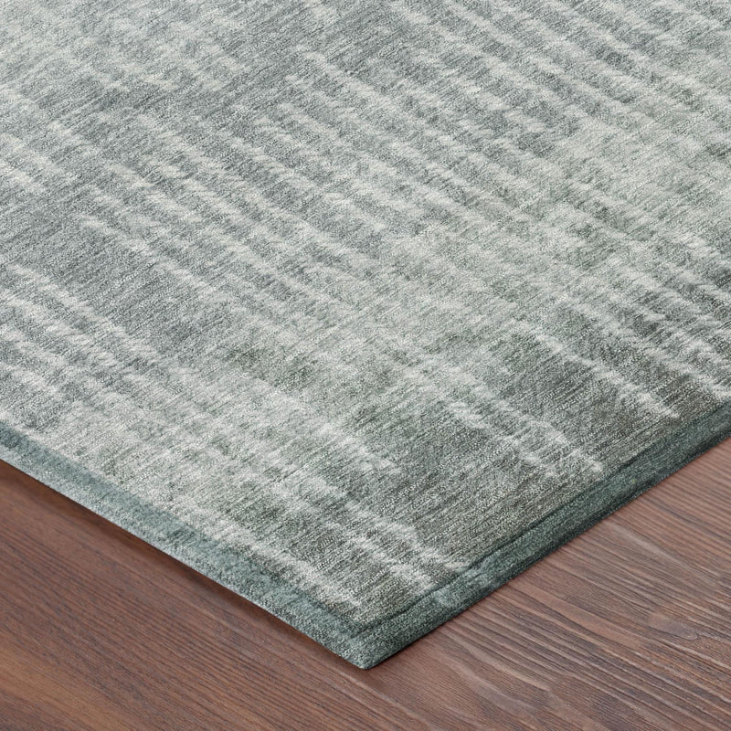 Corner detail of round abstract rug with sage-green tones and textured weave