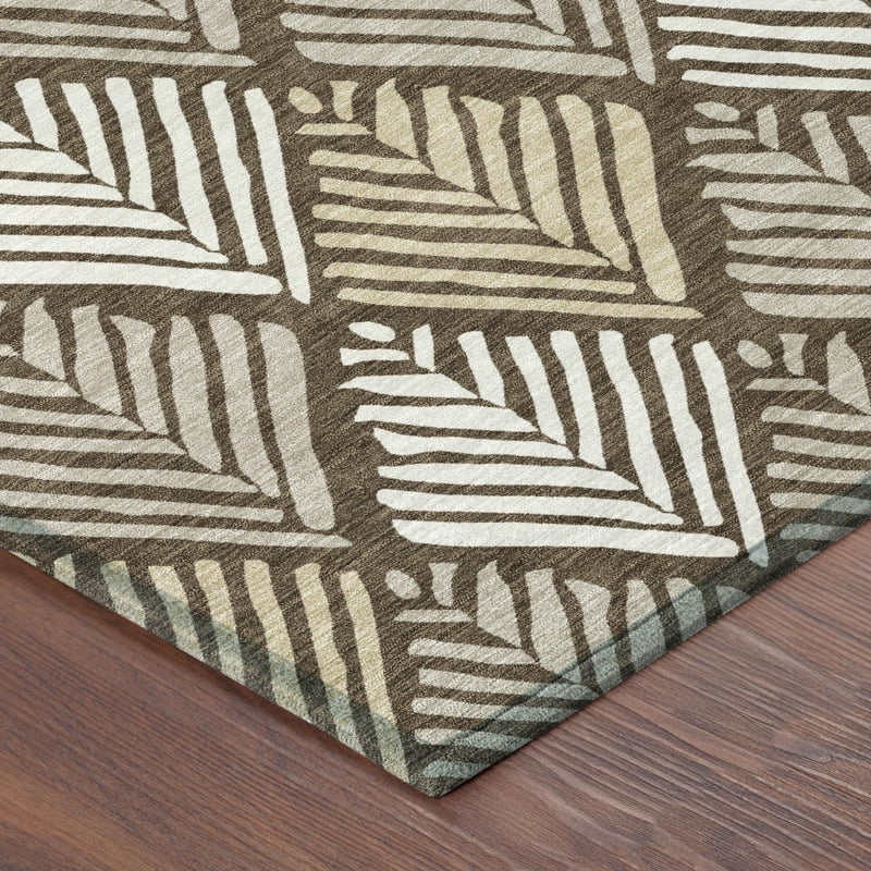 Corner view of geometric area rug with white and dark brown leaf stripe pattern on wood floor