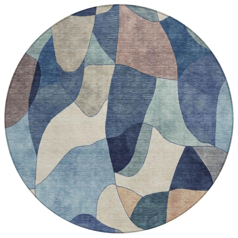 Round area rug with multicolor abstract camouflage-style shapes in blue, beige, and teal
