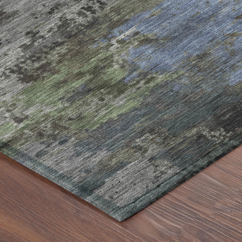 Corner view of abstract area rug with gray base and blue/green streaks