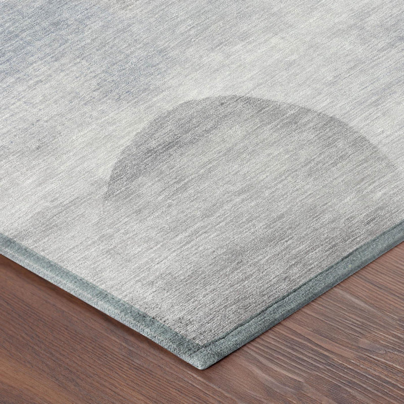 Corner view of light gray geometric area rug with blue border and textured weave