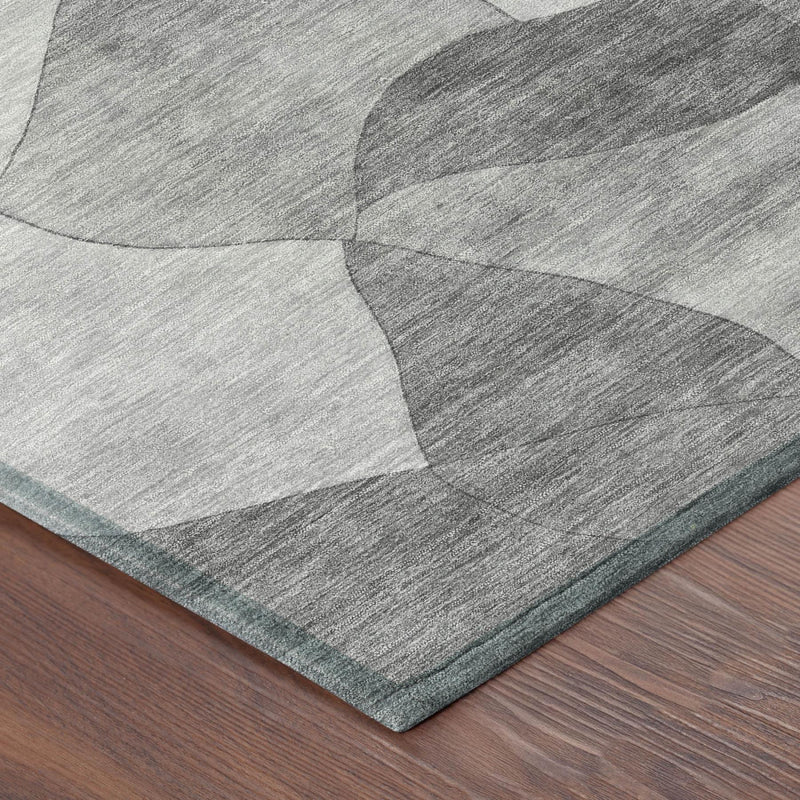 Corner detail of gray and silver abstract area rug with textured low-pile surface