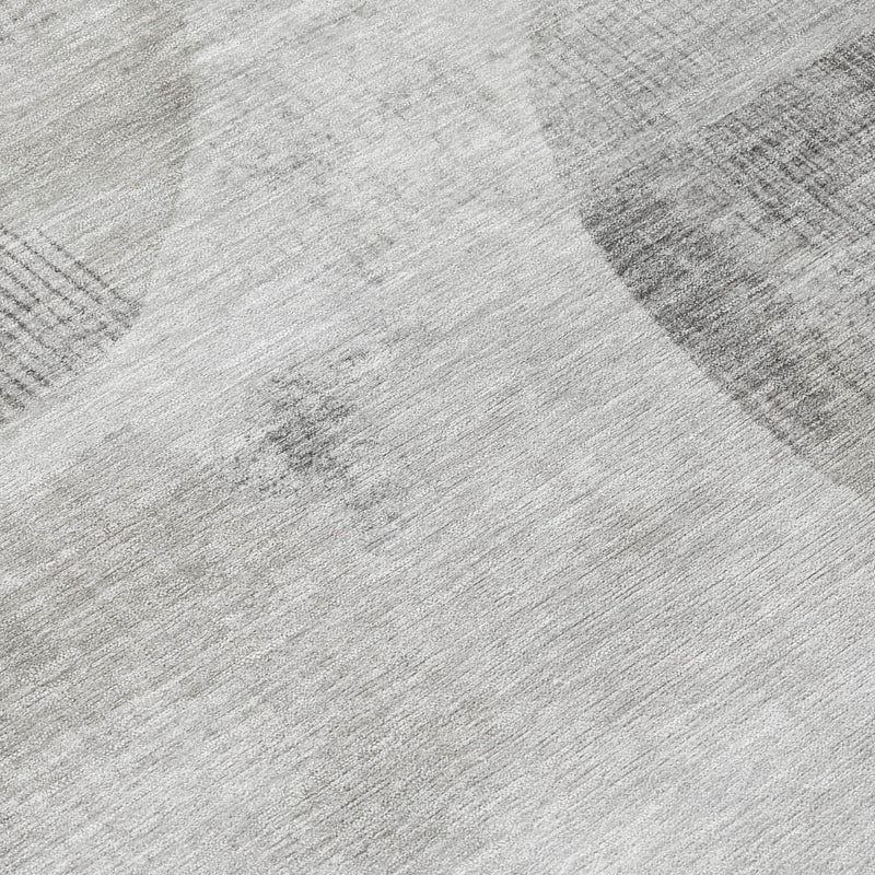 Close-up of light gray rug surface with woven texture and abstract oval motif
