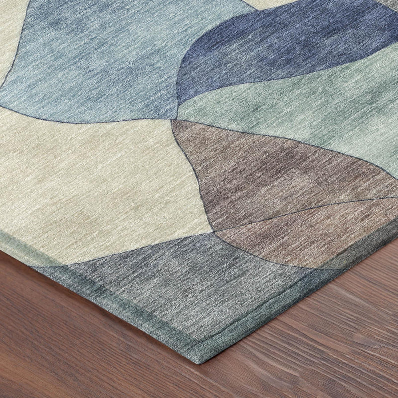 Abstract area rug corner with blue, navy, greenish, cream, and taupe patches