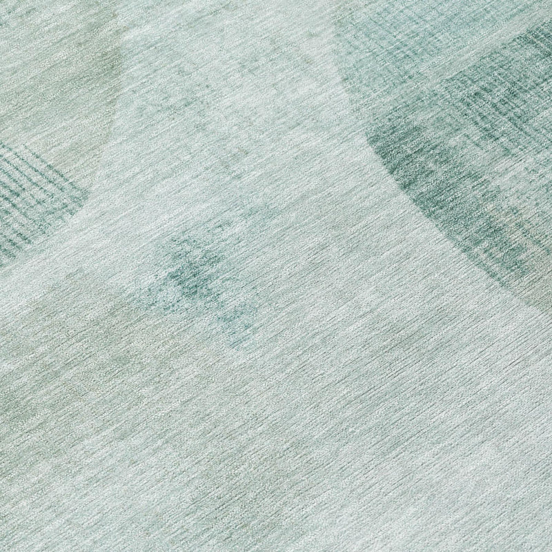 Light teal area rug with textured silver linework and abstract patchwork pattern