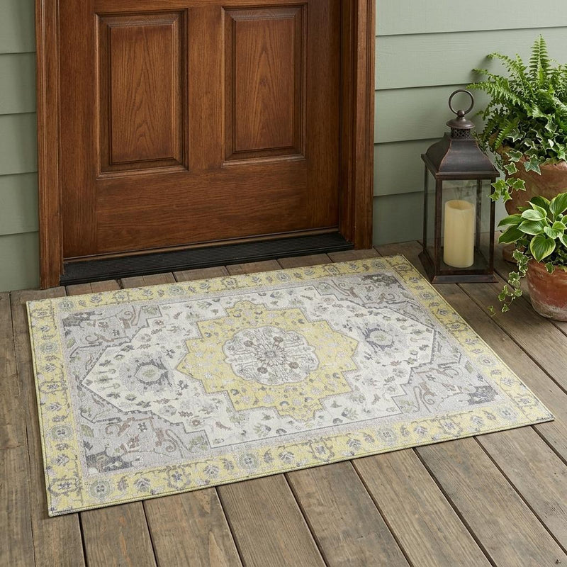 Oriental area rug laid on a wood floor with gray field and yellow decorative trim