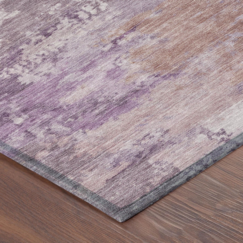 Corner close-up of abstract area rug with plum and purple distressed wash and bound edge