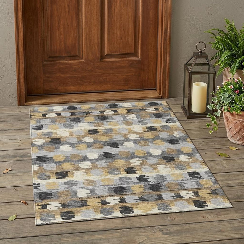 Abstract gray indoor outdoor rug with beige, gold, and dark charcoal accents.