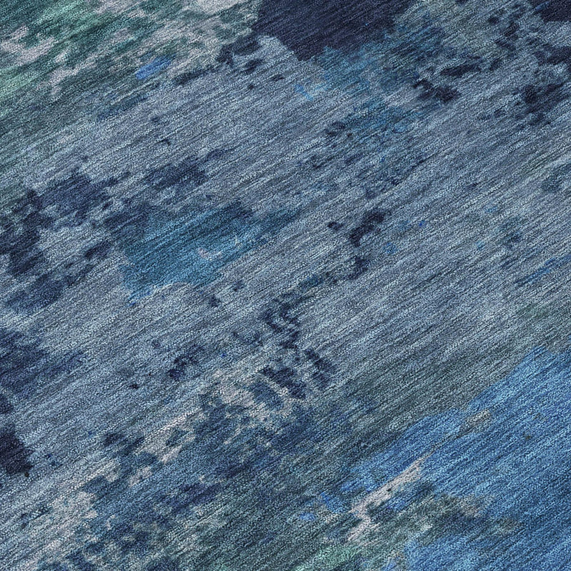 Blue and navy abstract wash area rug surface detail with textured pattern