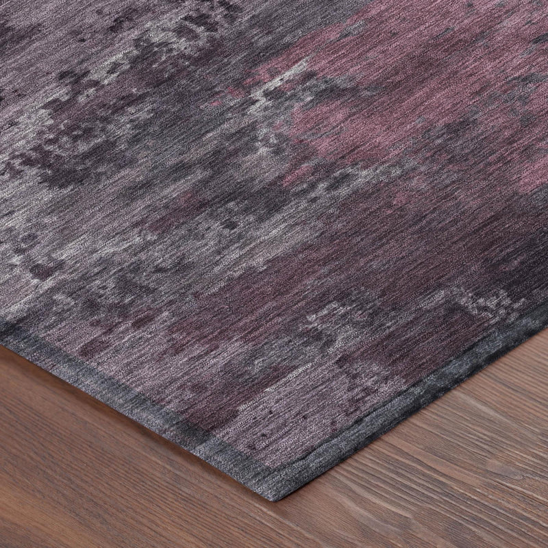 Corner view of abstract area rug with purple-gray fibers and maroon faded streaks
