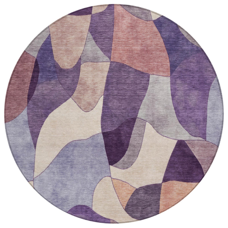 Round abstract area rug with plum, purple, and beige irregular patchwork design