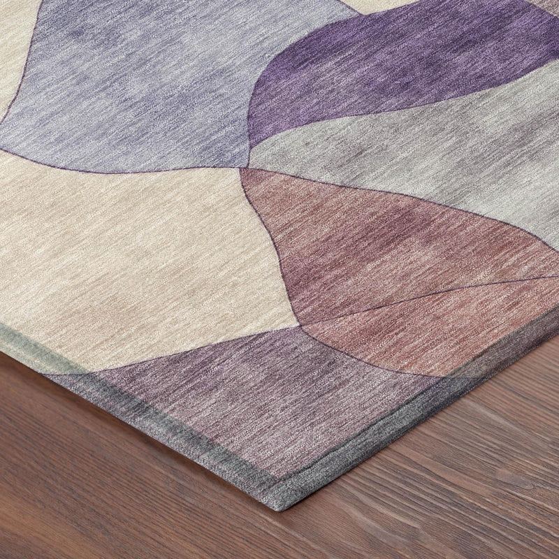Corner view of round abstract rug with layered-looking plum, purple, beige, and gray tones