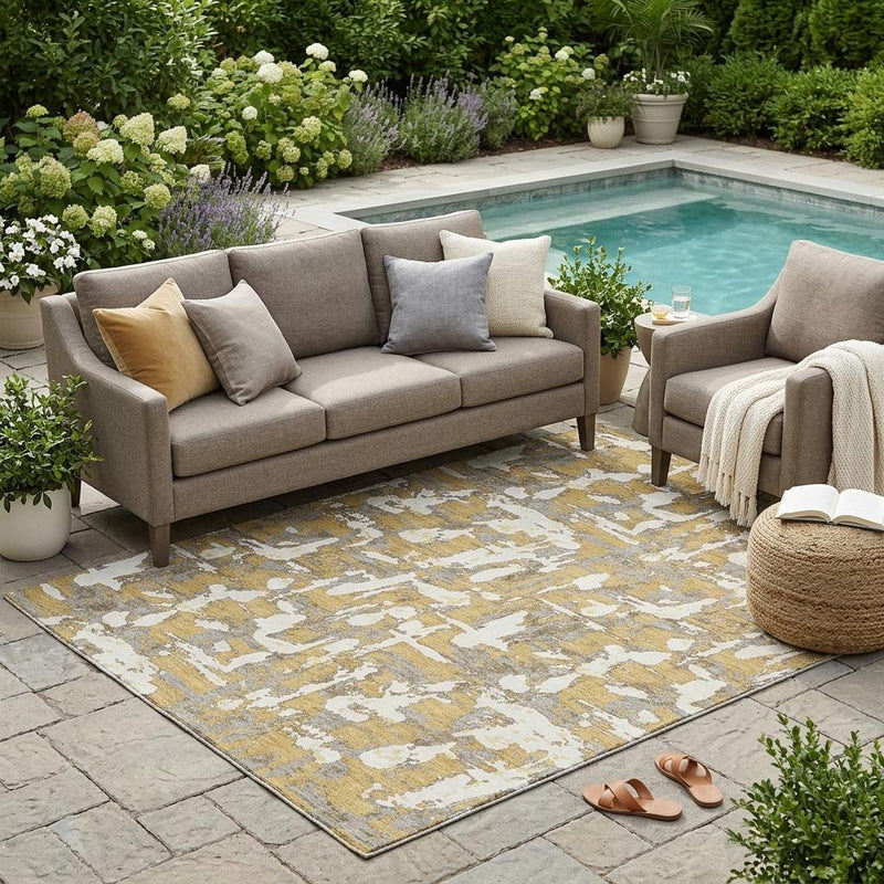 Outdoor-ready abstract area rug in gold and ivory with distressed pattern