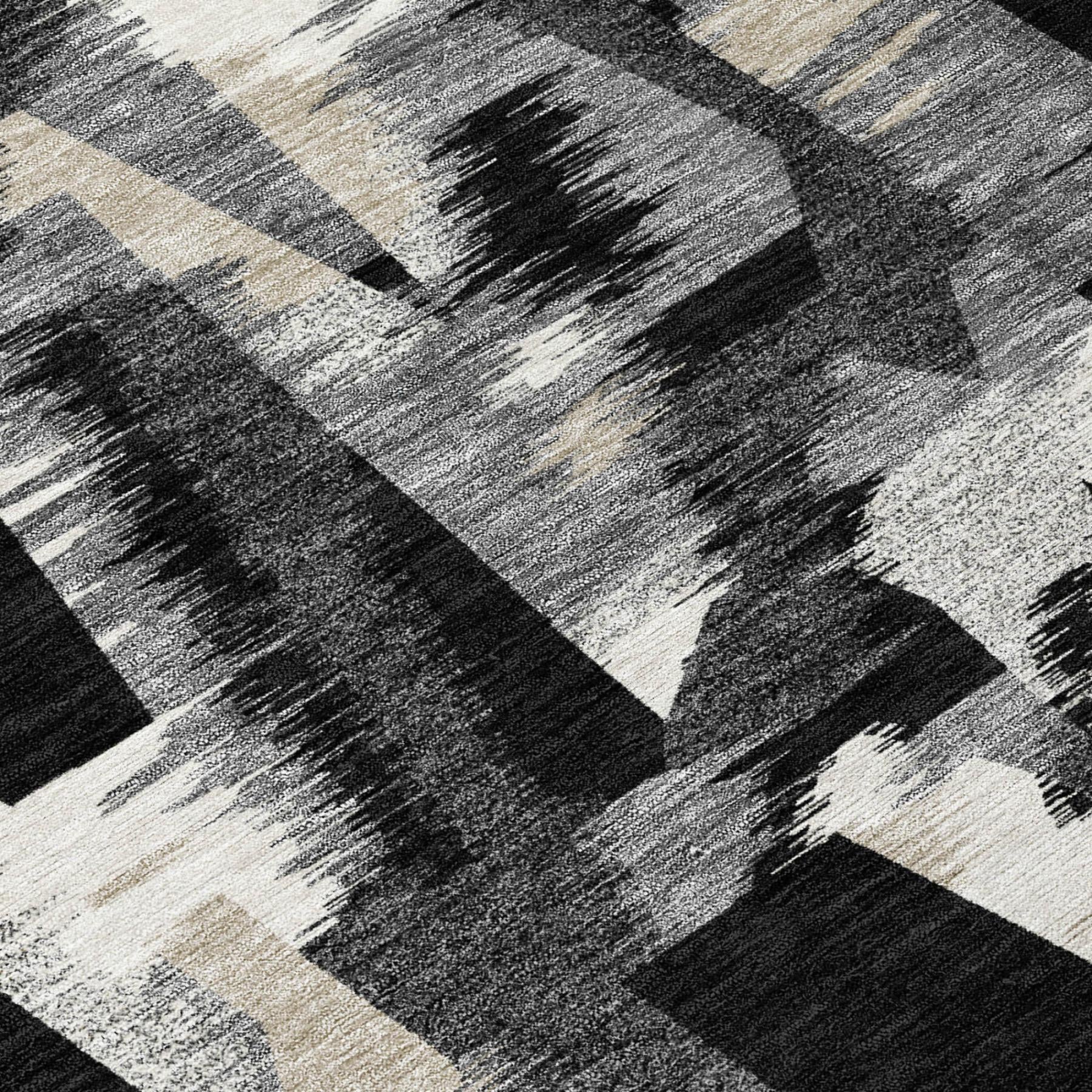 Abstract area rug surface with black, graphite, and beige brushstroke shapes.