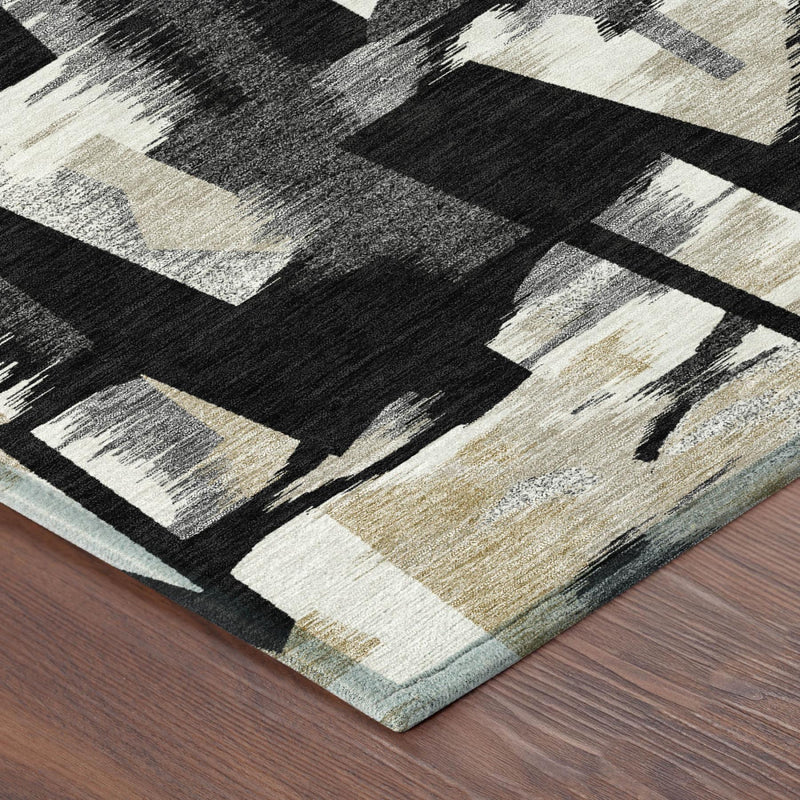Abstract area rug corner showing black and graphite blocks on beige with flat edge.