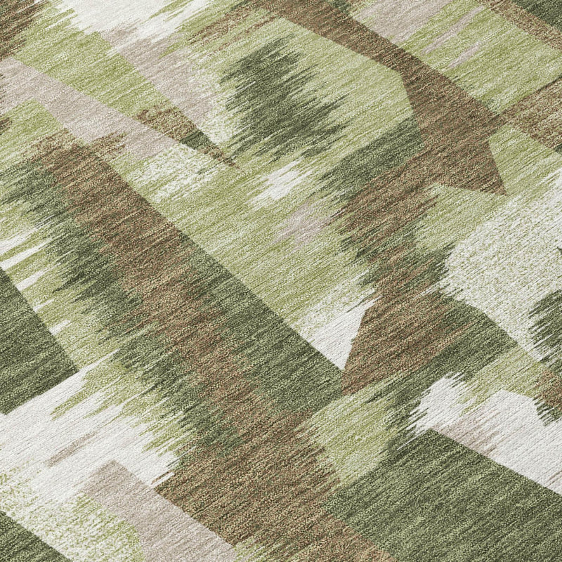 Close-up of abstract area rug pattern in dark green, sage, and cream brush blocks