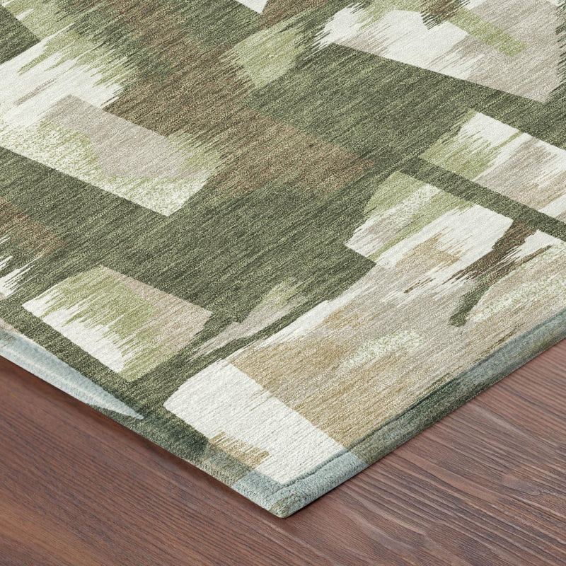 Corner view of olive green abstract rug with cream blocks and slightly fringed edge.