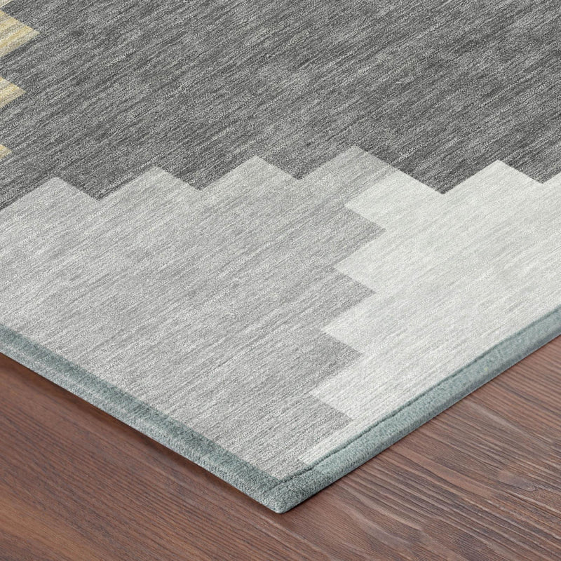 Corner view of gray geometric rug with beige/cream block shapes and light border