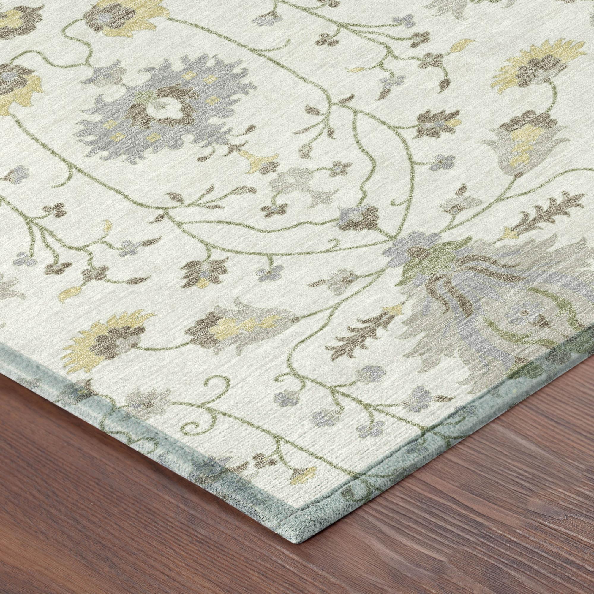 Corner of ivory round oriental rug showing silver-gray floral pattern and sage green border