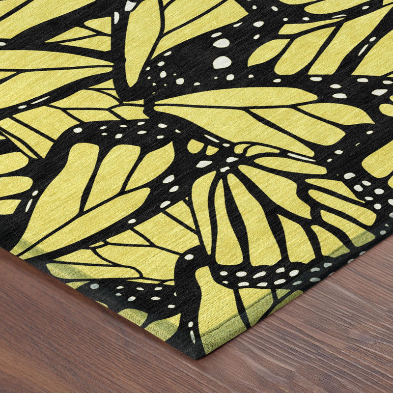 Yellow and black animal print area rug corner with bold leaf-and-butterfly motif