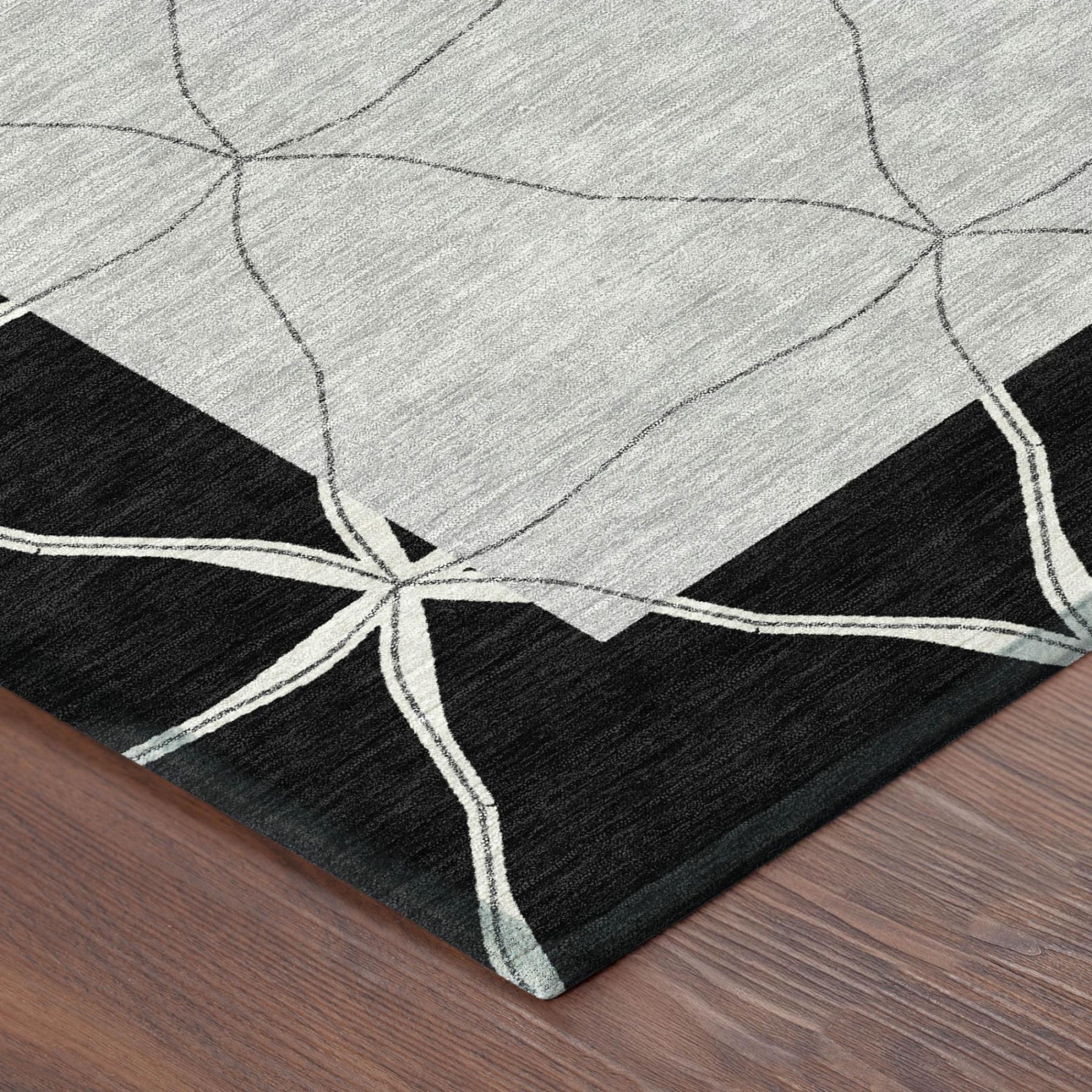 Corner of geometric area rug with black base, light gray diamonds, and white outline lines