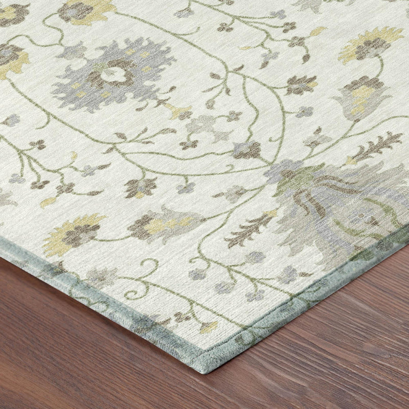 Ivory rug corner with ornate vine and floral pattern in gray, sage green, and pale gold
