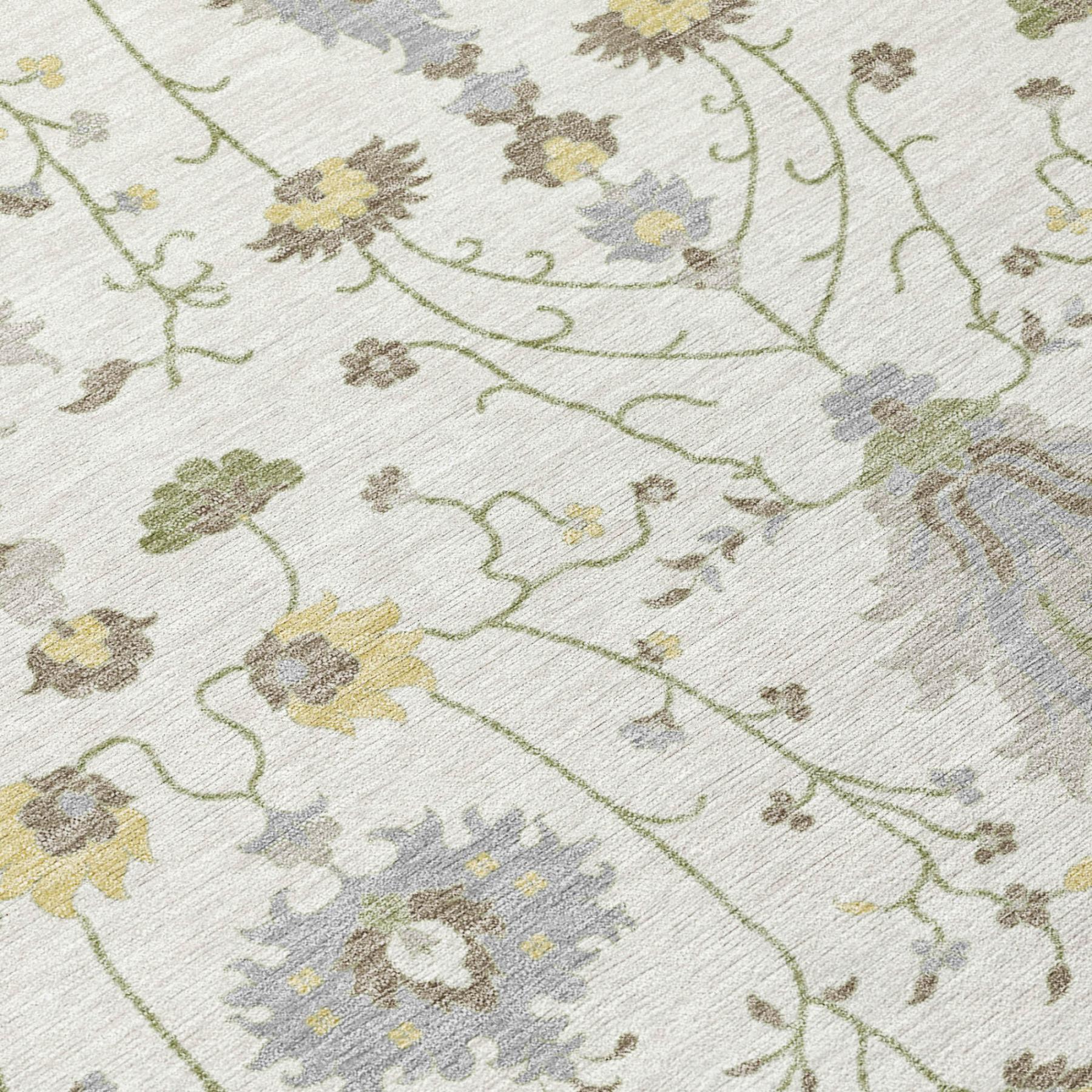 Close-up of ivory rug with green vine lines and gray floral motifs with pale gold accents